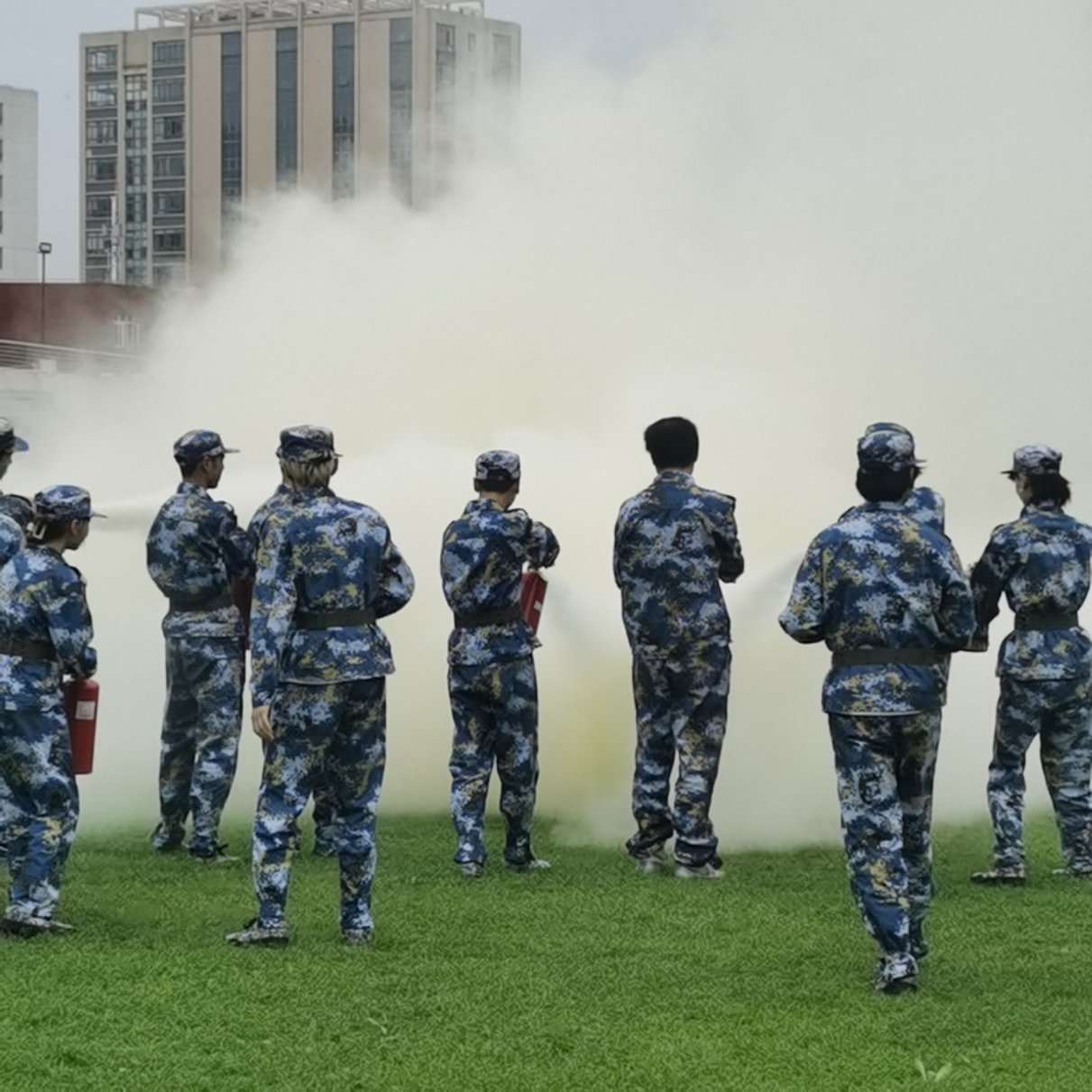 （图为同学们使用灭火器灭火）