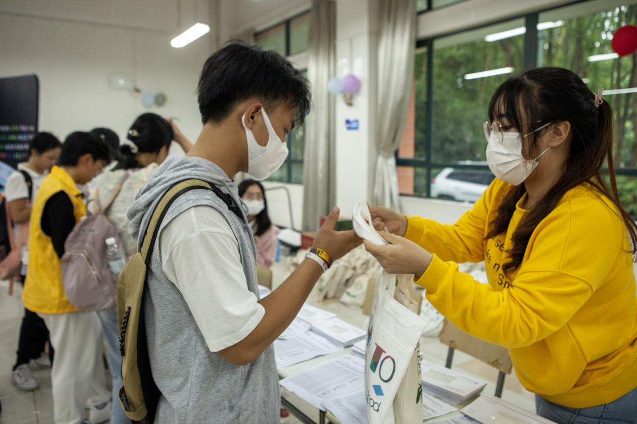 （图九为志愿者分发新生礼包）